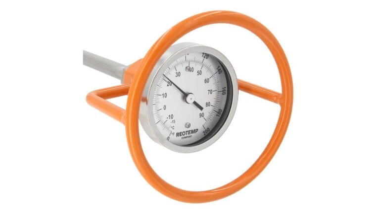 Compost thermometer probe inserted into dark compost inside a wooden bin