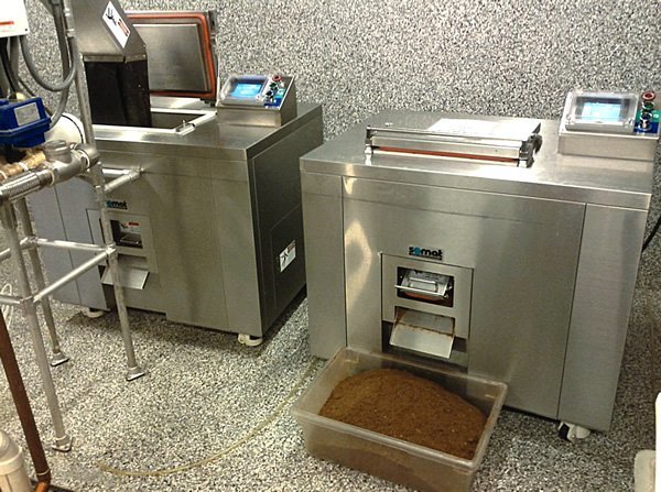 A countertop food waste dehydrator turning kitchen scraps into dry compost on a kitchen counter.