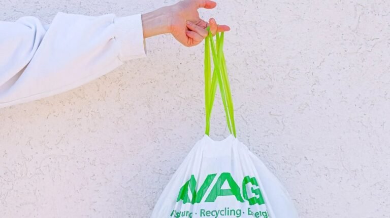Roll of biodegradable trash bags on a kitchen counter beside a basil plant
